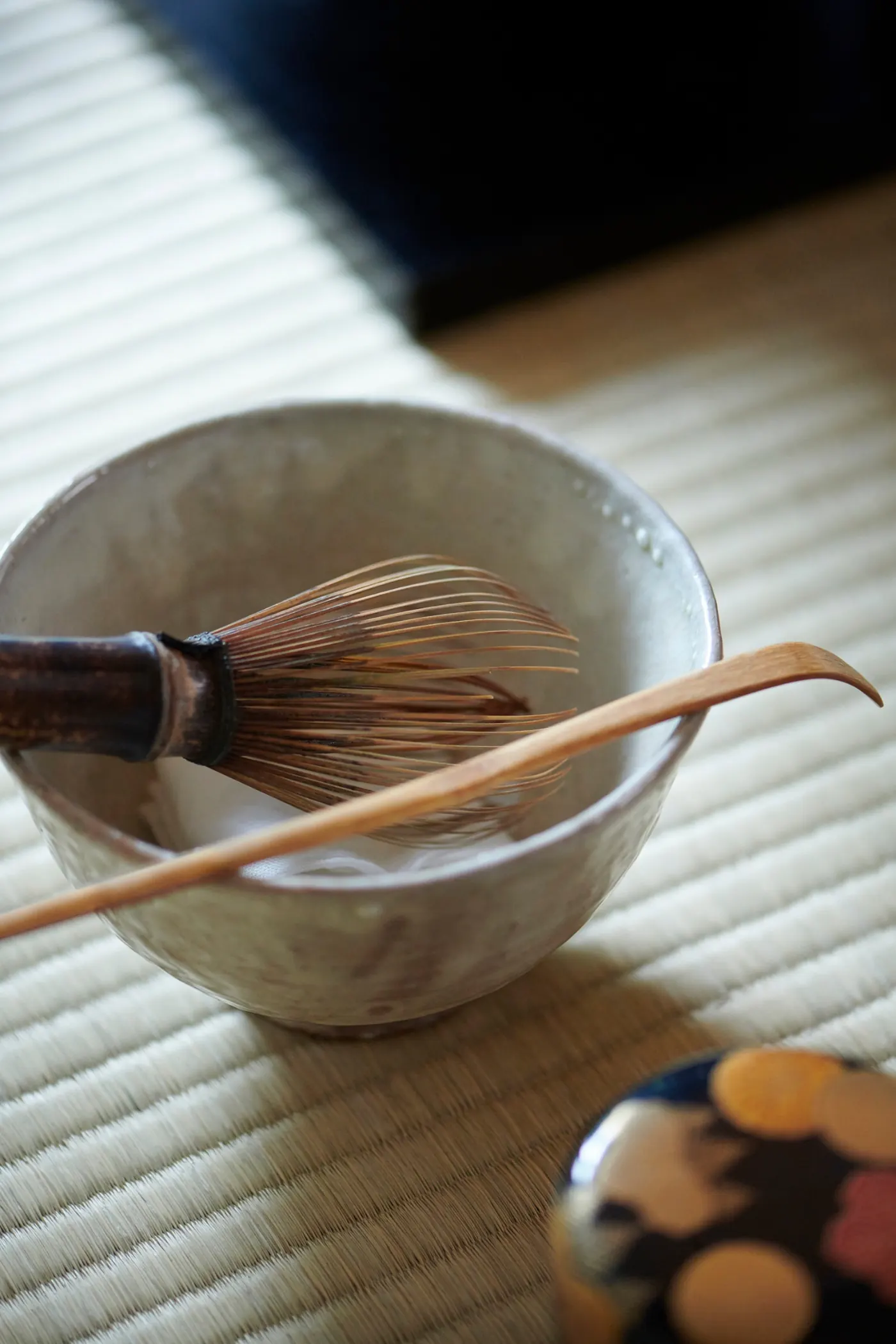 Chawan, chasen, and chashaku arranged on tatami
