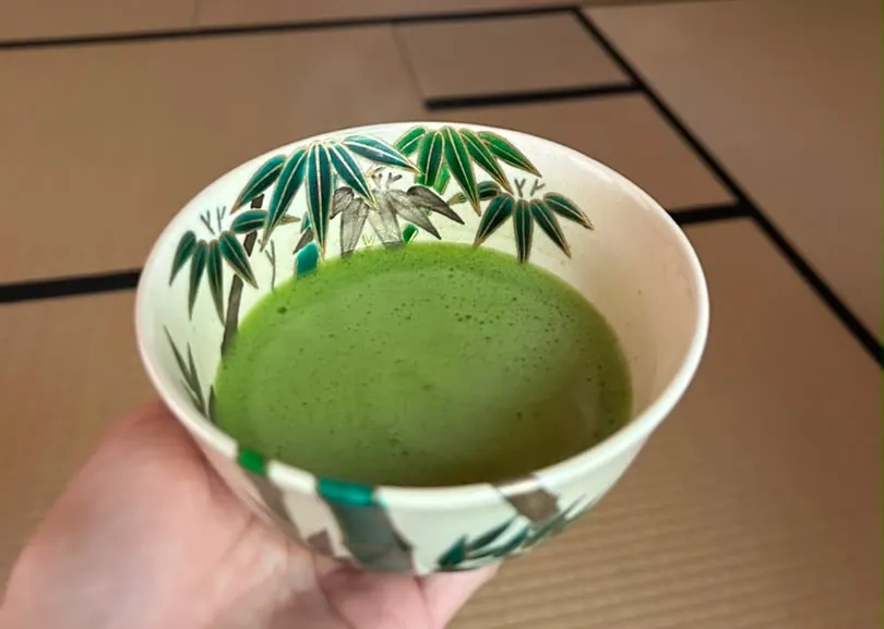 A bowl of usucha with fine foam, held over tatami